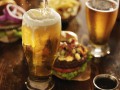 beer being poured into glass with gourmet hamburgers