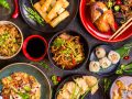 Assorted Chinese food set. Chinese noodles, fried rice, dumplings, peking duck, dim sum, spring rolls. Famous Chinese cuisine dishes on table. Top view. Chinese restaurant concept. Asian style banquet